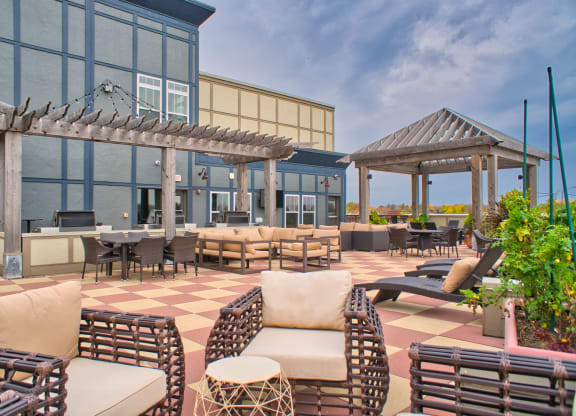 a rooftop patio with chairs and tables and grill stations