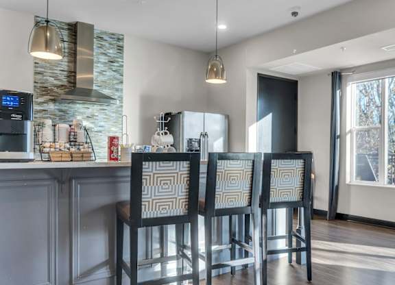 A kitchen with a bar area and four chairs.