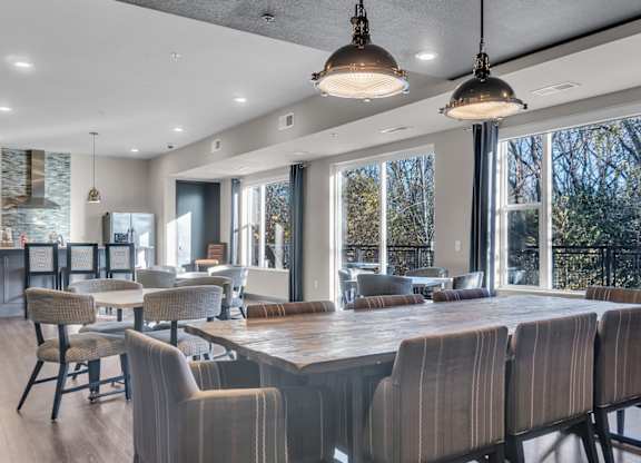 A modern dining room with a long table and chairs.