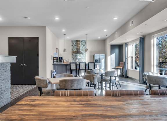A modern living room with a stone fireplace and a large window.