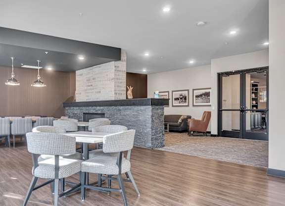 A modern dining room with a fireplace and chairs.
