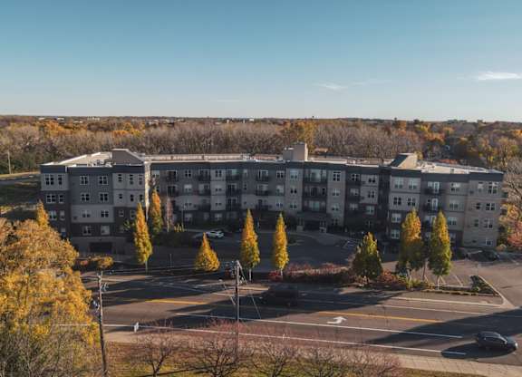 A large apartment complex with a parking lot in front.