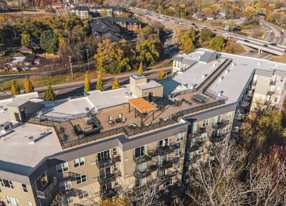 An aerial view of a multi-story apartment building surrounded by trees.