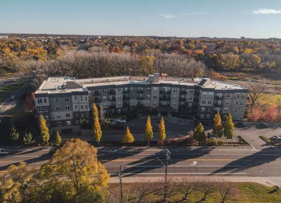 A large apartment complex surrounded by trees with autumn leaves.