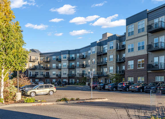 A parking lot in front of apartment buildings.