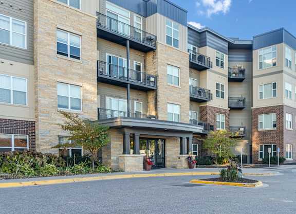 A large apartment complex with a parking lot in front.