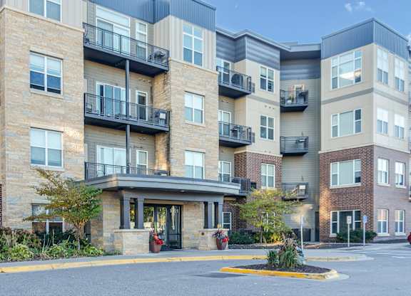 Apartment building with a parking lot in front.