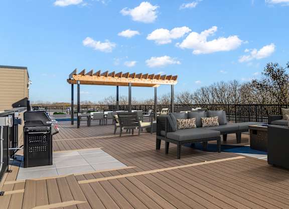 A wooden deck with a table and chairs and a canopy.