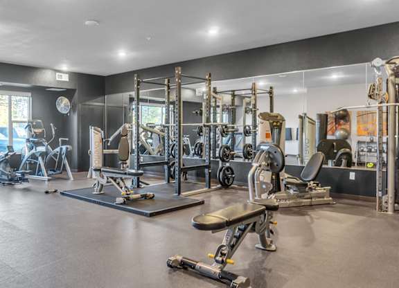 A spacious gym with a variety of equipment including treadmills, weights, and benches.