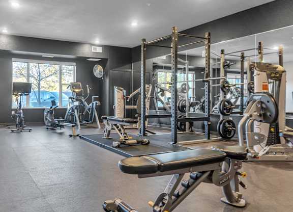 A spacious gym with a variety of equipment including treadmills, weights, and exercise machines.