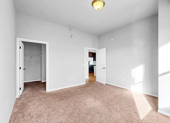 A room with white walls and carpeted floor with a light on.