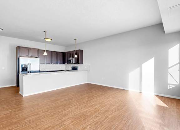 A spacious room with wooden flooring and white walls.