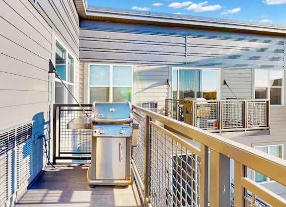 A balcony with a railing and a trash can.