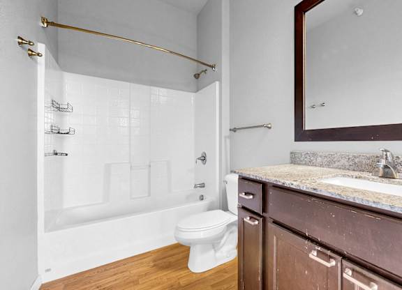 A bathroom with a white toilet and a marble countertop.