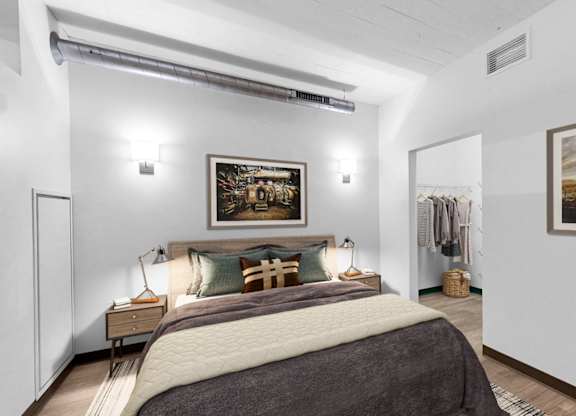 A bedroom with a large bed and two pictures on the wall.