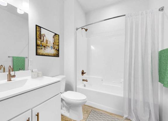 A white bathroom with a toilet, sink, and shower.