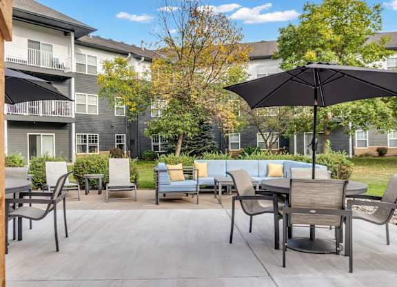 A patio with a table and chairs and an umbrella.