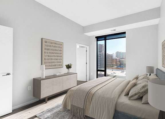 A bedroom with a large bed and a view of the city.