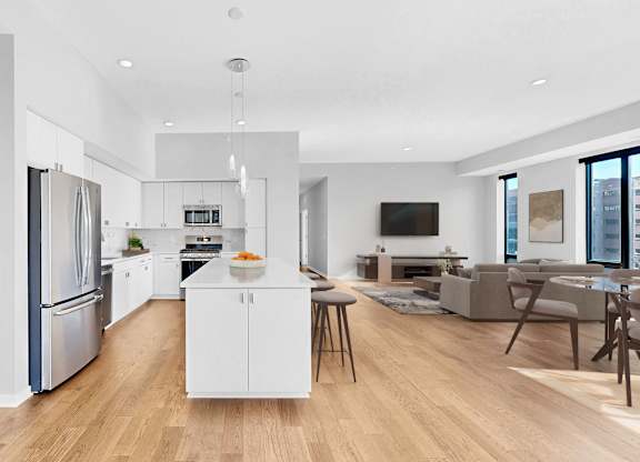 A modern kitchen with a white island and stainless steel appliances.