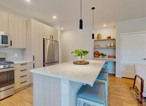 a kitchen with a large island and stainless steel appliances