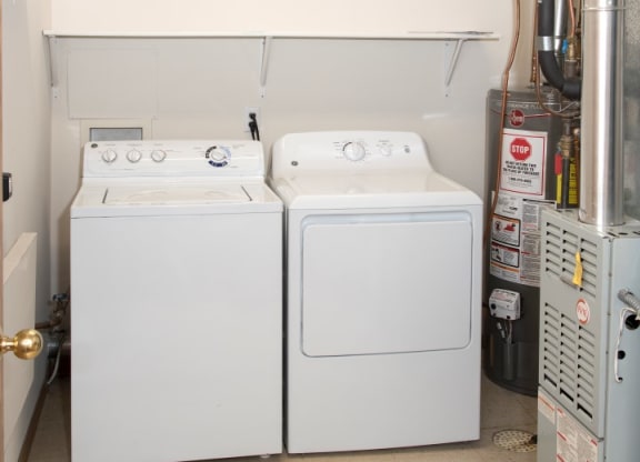 Laundry room with full size washer and dryer and shelving