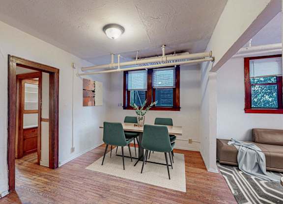 A room with a dining table and chairs.