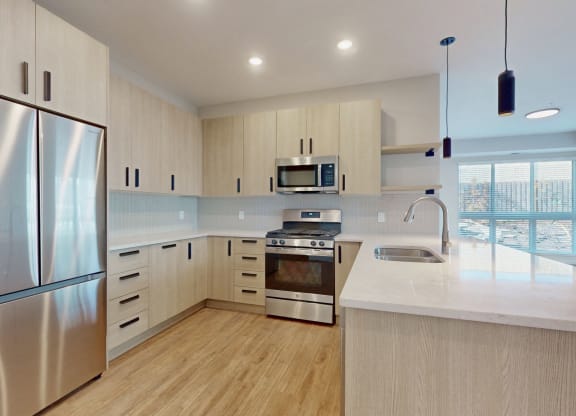 a white kitchen with stainless steel appliances and white counter tops