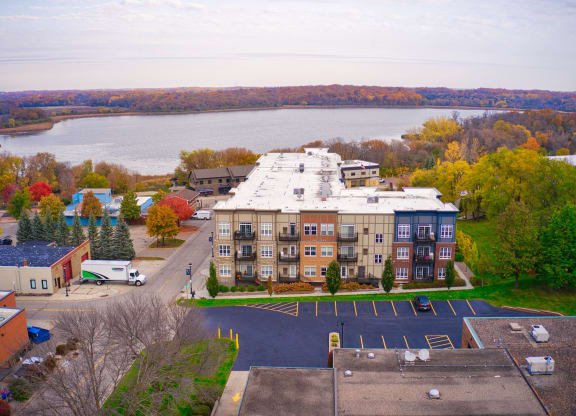 an aerial view of a building with a lake in the background