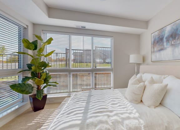 a large bedroom with bed and large windows