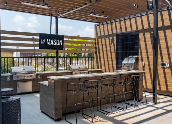 an outdoor patio with a grill and a bar at The Mason, St. Paul, MN