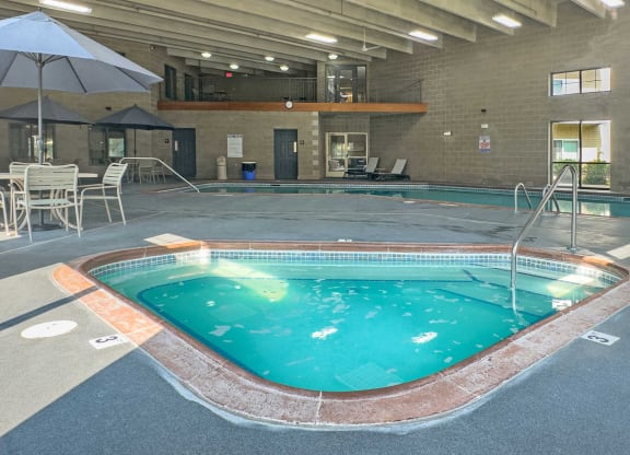 indoor spa and pool with seating and balcony