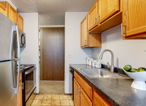 a kitchen with wooden cabinets and stainless steel appliances