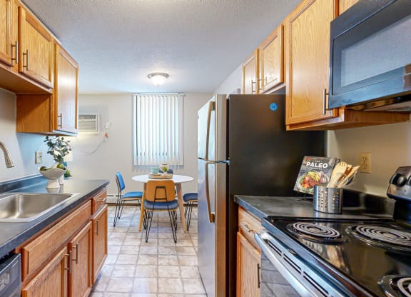 a kitchen with black countertops and wooden cabinets