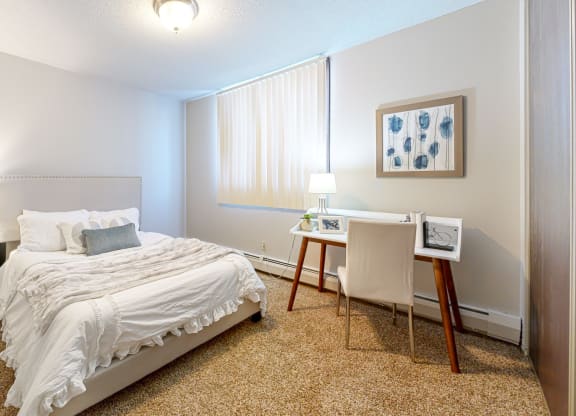 a bedroom with a bed and a desk