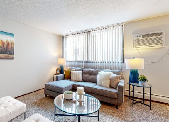 a living room with a couch coffee table and two windows