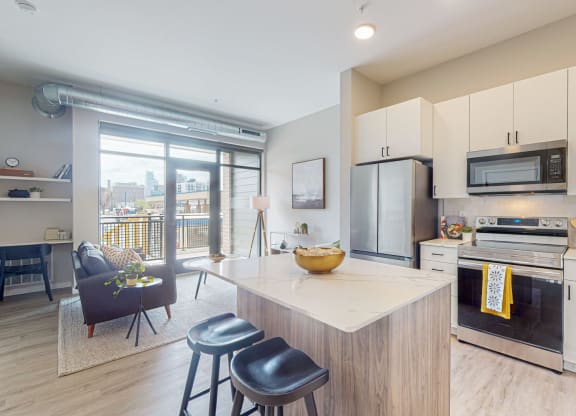 a kitchen with white cabinets and a large island with a marble countertop