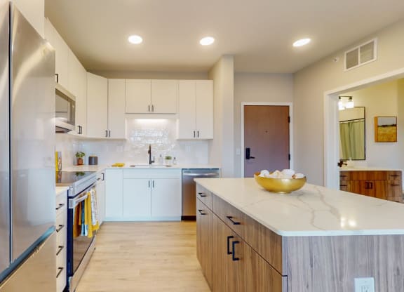 a kitchen with white cabinets and stainless steel appliances