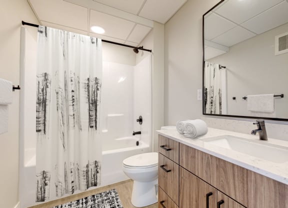 a bathroom with a toilet sink and shower in a 555 waverly unit