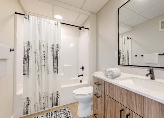 a bathroom with a toilet sink and shower in a 555 waverly unit