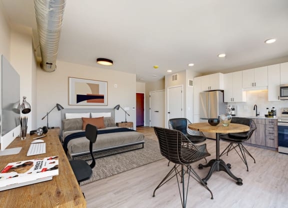 a bedroom with a bed and a table and chairs in a room