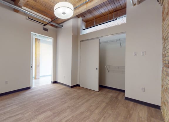 an empty room with white walls and wood floors