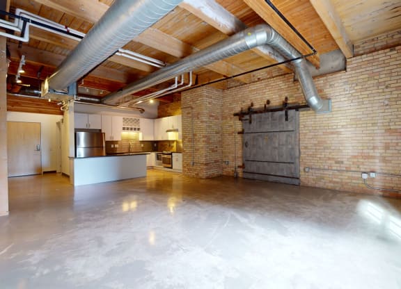 a large room with a kitchen and a large window