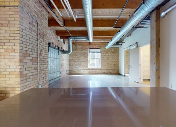 a large room with brick walls and a large table in the middle of it