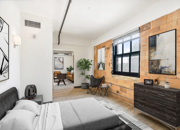 a bedroom with a bed and a exposed brick wall