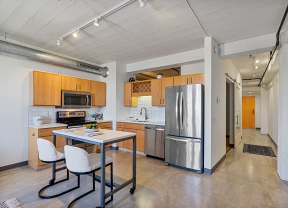 a kitchen with stainless steel appliances and a table with chairs