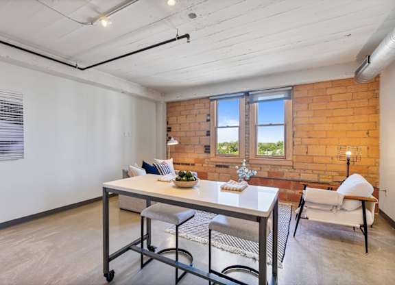 A dining room with a table and chairs.
