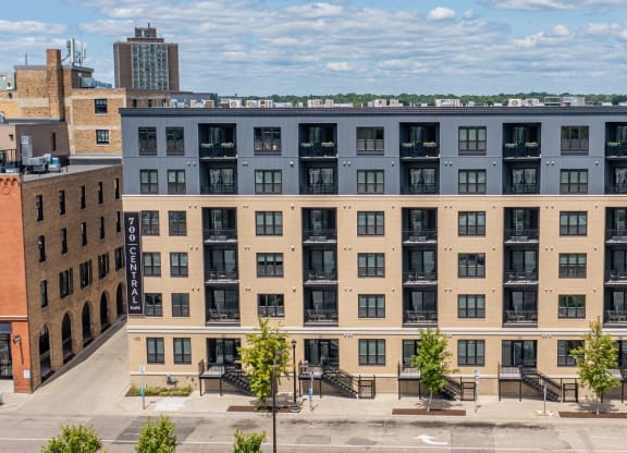 a large apartment building with a blue roof and tan facade