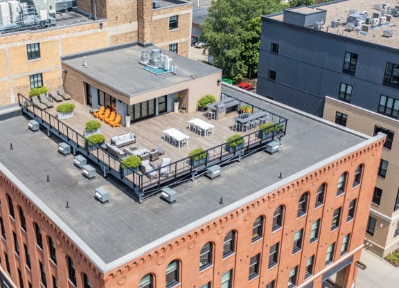 an aerial view of a brick building with a rooftop deck