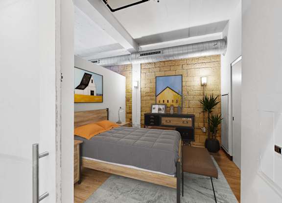 A bedroom with a bed, a chair, and a plant.