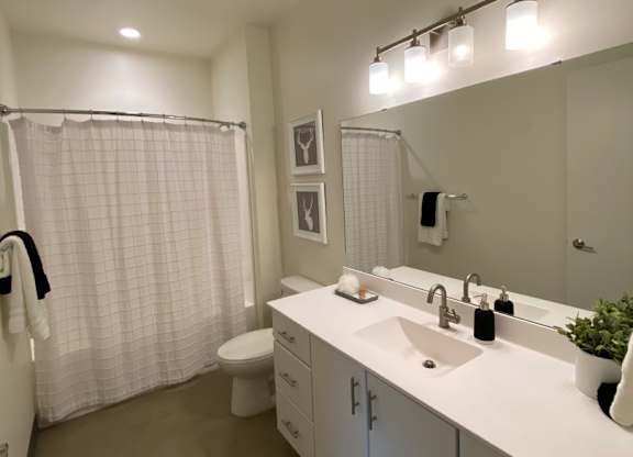 A bathroom with a white sink and a white toilet.
